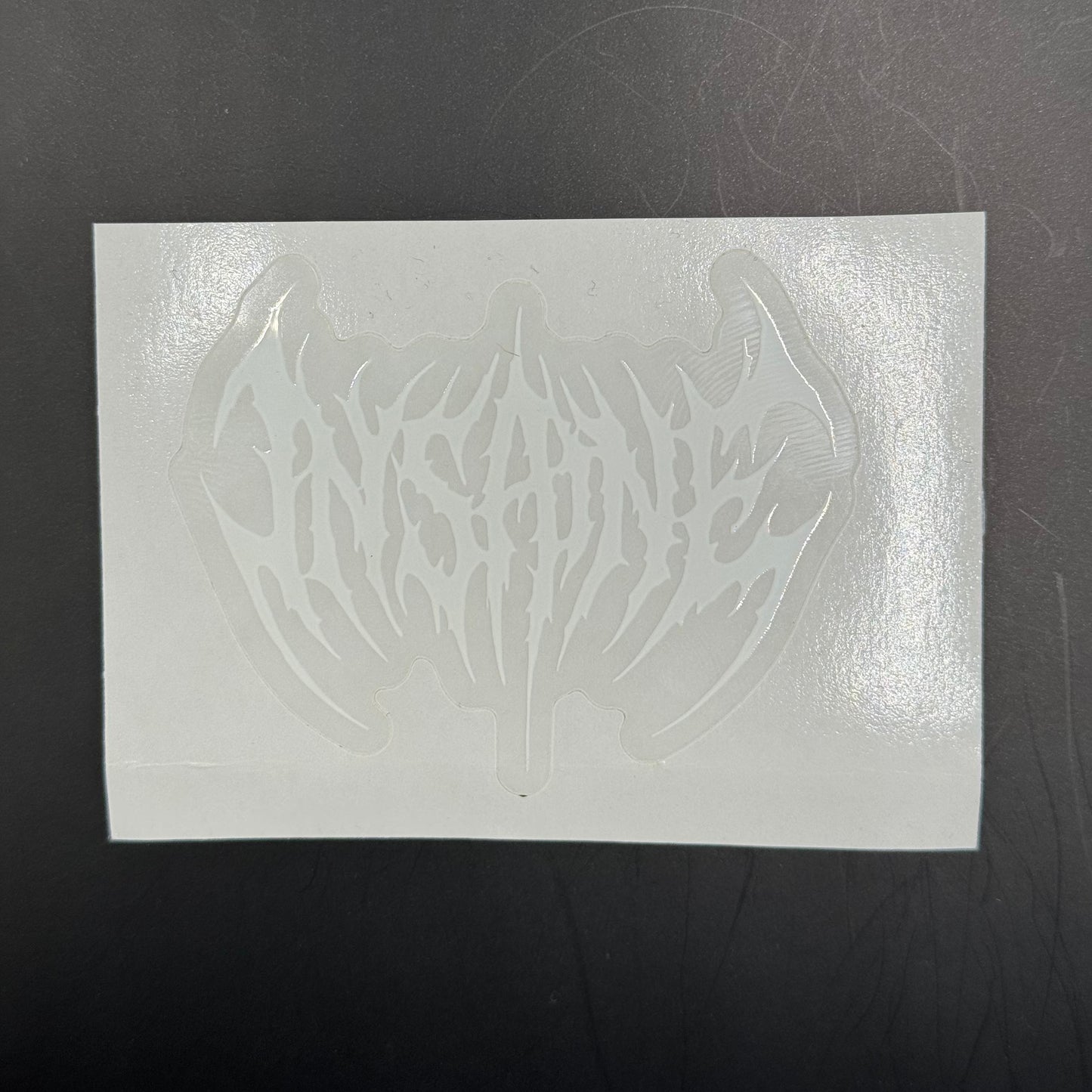 White rectangular sheet with a cut-out design on a dark surface
