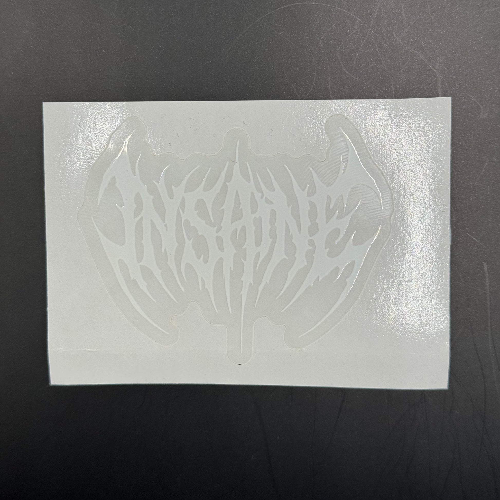 White rectangular sheet with a cut-out design on a dark surface
